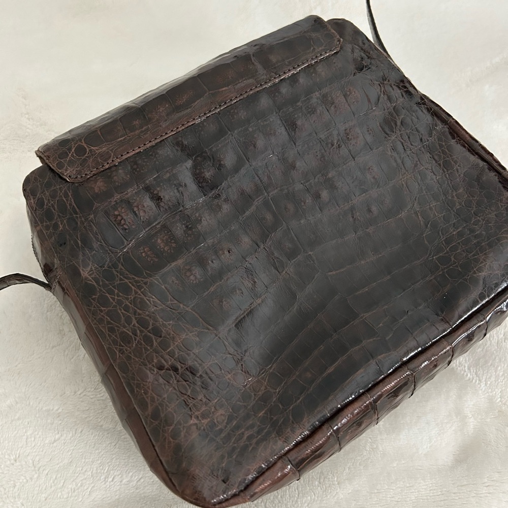 Crocodile chocolate mini crossbody with multiple zipper pockets.